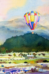 Watercolor landscape painting of hot air balloon on mountain.