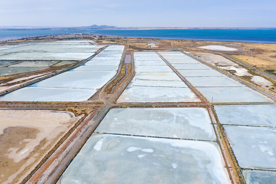 Aerial view of multi-colored salt pans at a commercial saltworks