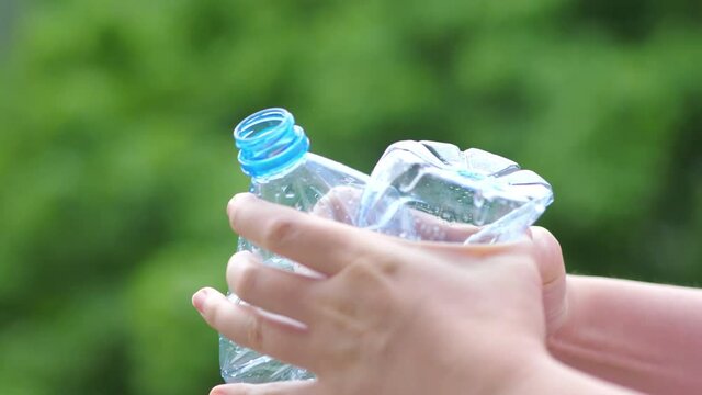Crushing the plastic bottle with hands in 4k slow motion 60fps
