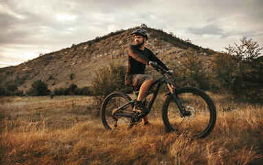 Active man riding electric mountain bike in nature