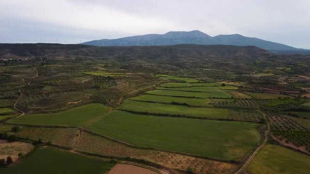 Drone view of a mountain with windfarm turbines