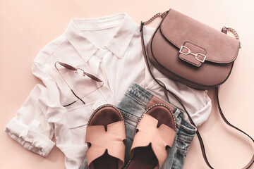 Feminine summer fashion flat lay with blouse, handbag, sunglasses, shorts and slippers on beige...
