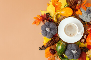 Autumn flat lay composition with dry leaves wreath frame and coffee latte cup on neutral beige...