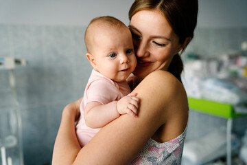 Happy mother and baby hugging and playing together.