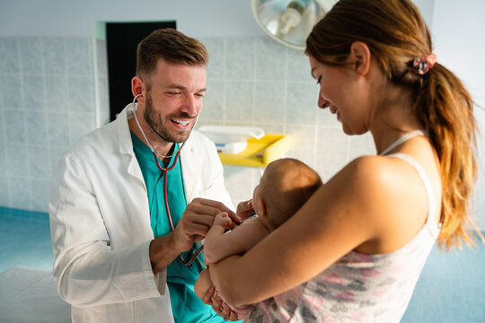 Happy pediatrician doctor with baby checking possible heart defect