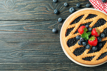 Delicious blueberry pie on rustic wooden background with kitchen towel