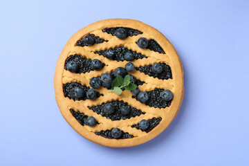 Delicious blueberry pie on violet background, top view