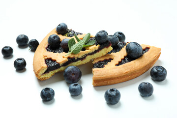 Pieces of blueberry pie with berries on white background