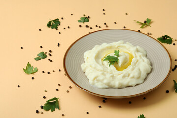 Plate of mashed potatoes and spices on beige background