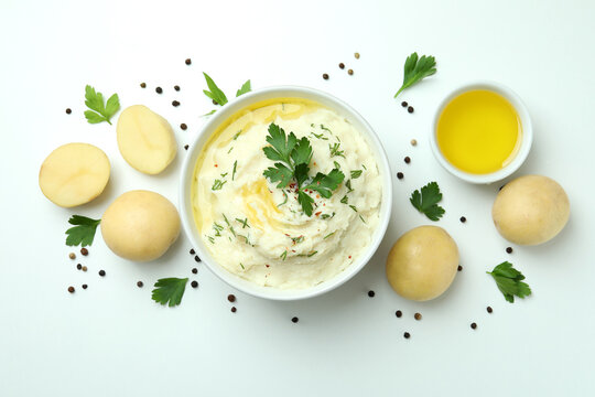 Plate of mashed potatoes and ingredients on white background