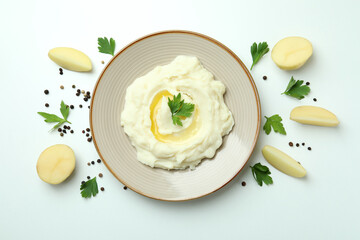 Plate of mashed potatoes and ingredients on white background