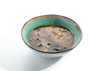 Japanese Miso Seafood Soup - traditional seafood soup with Japanese miso paste and seafood. Ingredients of soup include mushrooms, seaweed and seafood. Miso soup in bowl isolated on white background
