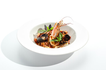 Seafood spaghetti pasta - spaghetti plate with seafood mix. Pasta dish with shrimp, mussel and octopus. Restaurant gourmet seafood and pasta food plate isolated on white background..
