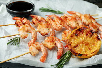 Tasty grilled shrimps on baking paper, close up