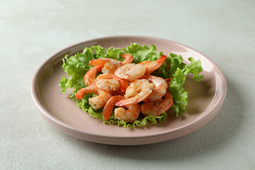 Plate of grilled shrimps on white textured table