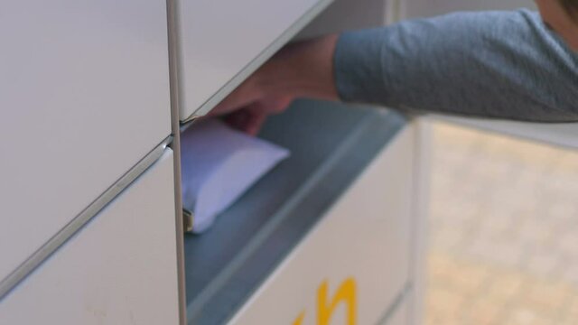 Collecting a parcel from a parcel locker in 4k slow motion 60fps