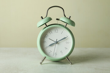 Stylish mint alarm clock against beige background