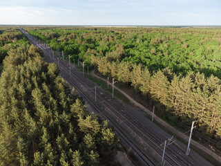 Fototapeta na wymiar Aerial view of railroad in sunny summer day in forest. Top view of Logistics, trade, shipping ways. 