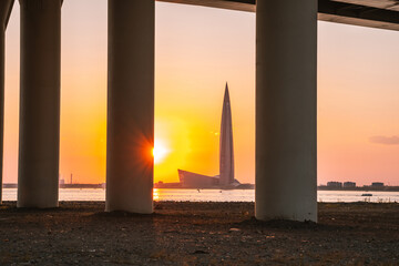 View of the Lakhta Center skyscraper. Beautiful sunset with orange sky over the bay. Saint Petersburg, Russia - 20 June 2021