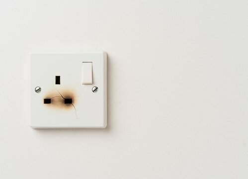 Fire damaged electrical wall power socket with copy space