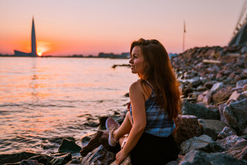 A young girl and a view of the Lakhta Center skyscraper at a beautiful sunset in St. Petersburg
