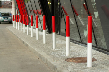 Red posts in the parking lot. Car traffic limiters.