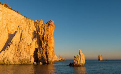 Sunset view of the spectacular walls rocciosedella south coast of uninhabited Poliegos close to Milos in the Greek Cyclades