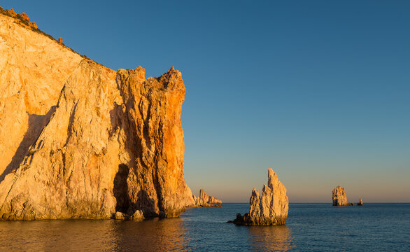 Sunset view of the spectacular walls rocciosedella south coast of uninhabited Poliegos close to Milos in the Greek Cyclades