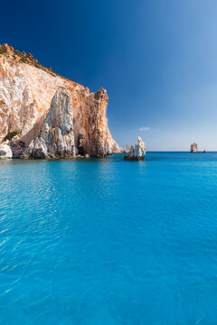 Spectacular rock faces on the turquoise sea of the south coast of the uninhabited island of Poliegos near Milos in the Greek Cyclades