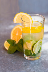 Lemonade with lemon, lime and mint. Illuminating summer drink with ice. Bright mojito in a glass.