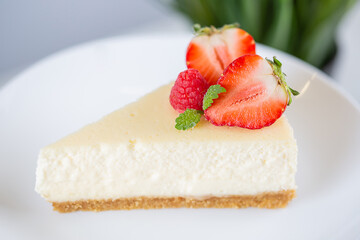 close-up of strawberry cheesecake on a white plate on a cake stand