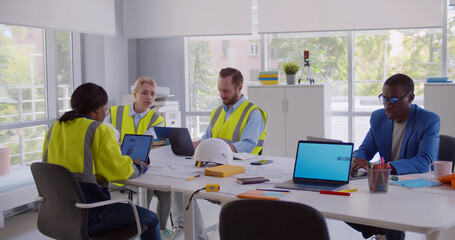 Obraz premium Engineers in uniform walking in office and greeting colleagues