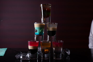 Barman preparing cocktail shots at the bar counter. Barman mixing drinks at the night club..