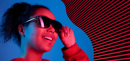 Young beautiful African girl in black sun glasses isolated over blue striped background in neon light. Concept of beauty, fashion,ad. Flyer - Powered by Adobe