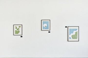 Minimal background image of three abstract paintings on white wall in contemporary art gallery,...