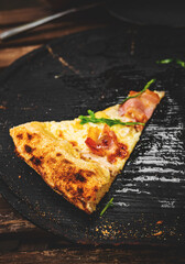 last slice of pizza on black wooden board in cafe