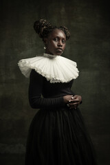 Portrait of medieval African young woman in black vintage dress with big white collar posing...
