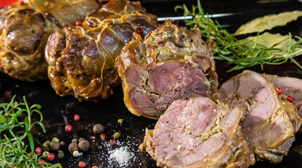 meat dish baked in the oven decorated with spices and rosemary on a dark background