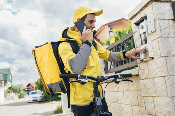 Male courier with bicycle delivering packages using smartphone