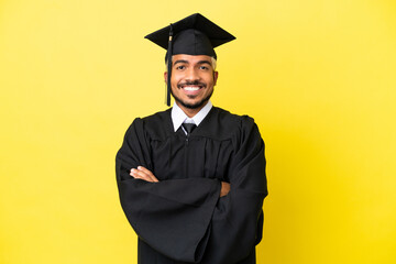 Young university graduate Colombian man isolated on yellow background keeping the arms crossed in...