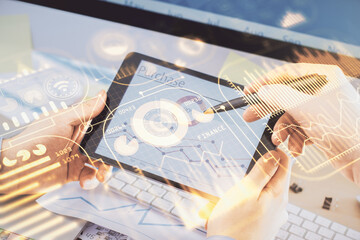 Double exposure of man's hands holding and using a digital device and tech theme hologram drawing....
