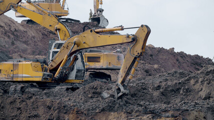 Large construction yellow excavators on construction site in quarry 