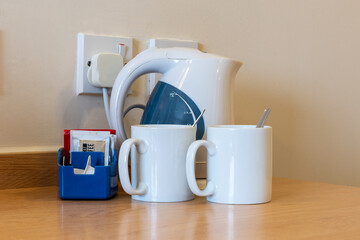 Basic tea and coffee making facilities in a hotel with electric kettle, mugs, spoons, tea, coffee...