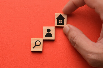 Wooden blocks with magnifying glass, people and home icons. House search, buying and selling real estate concept.