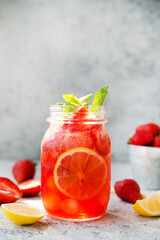 Homemade strawberry lemonade with ice in a jar, summer cold cocktail