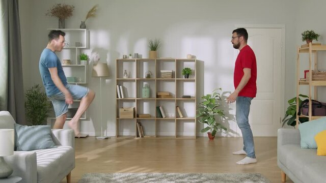 Young men playing football. Funny man dribbling the ball, enjoying his time together with bro - happy family, recreational pursuit concept 4k footage