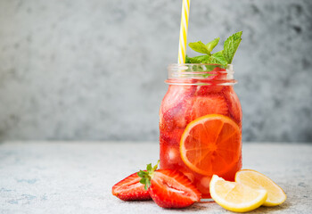 Homemade strawberry lemonade with ice in a jar, summer cold cocktail, selective focus