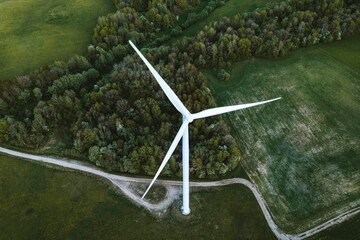 Aerial view of windmill turbine standing in green landscape in Lithuania.