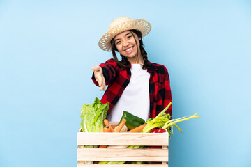Young farmer Woman holding fresh vegetables in a wooden basket shaking hands for closing a good deal