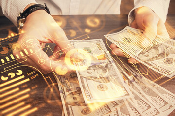 Fototapeta na wymiar Multi exposure of Tech drawing hologram and USA dollars bills and man hands. Technology concept.
